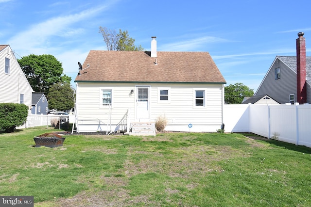 713 Cooper St, Florence, NJ 08518 - rear view of property featuring a chimney, a fenced backyard, a shingled roof, entry steps, and a lawn