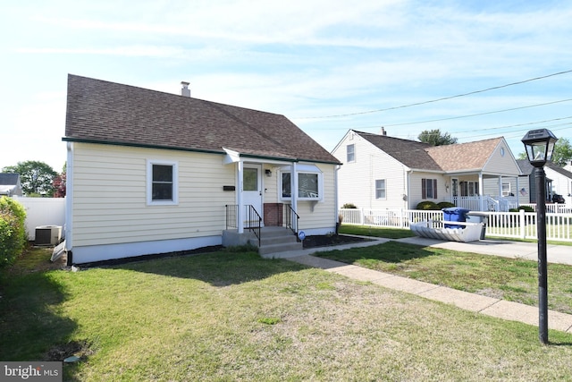 713 Cooper St, Florence, NJ 08518 - view of front of property featuring cooling unit, a front lawn, roof with shingles, and fence