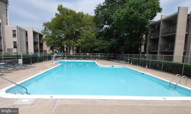 community pool with fence and a patio