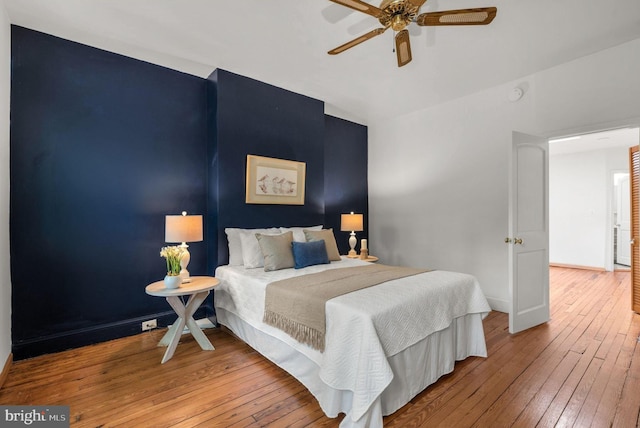bedroom featuring hardwood / wood-style flooring, baseboards, and ceiling fan