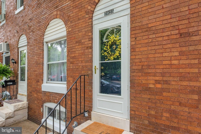 doorway to property featuring brick siding