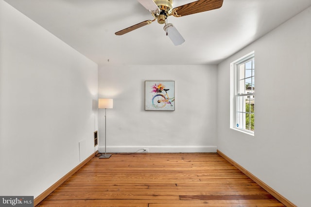 spare room featuring light wood-style floors, baseboards, and ceiling fan