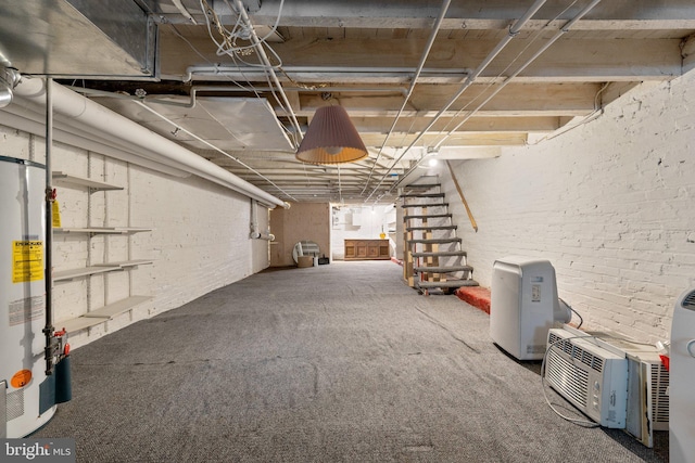 unfinished basement with gas water heater, carpet, stairs, and brick wall