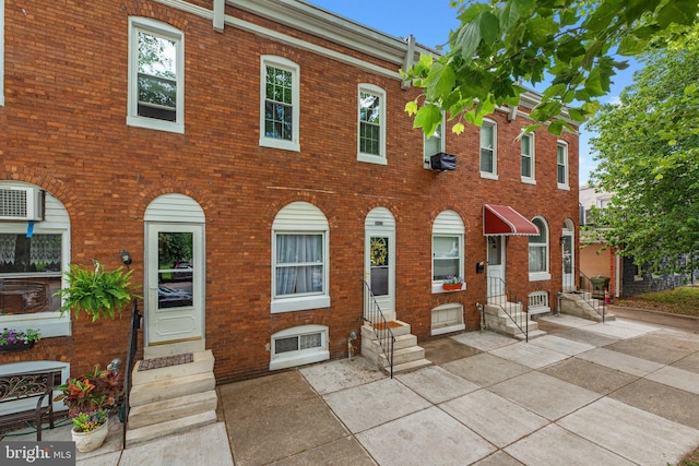 view of front facade with entry steps and brick siding