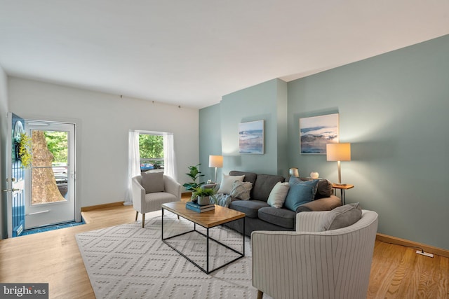 living area with light wood-type flooring and baseboards
