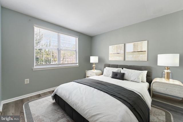 bedroom featuring baseboards and wood finished floors