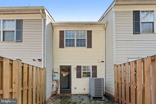 rear view of property featuring central AC and a fenced backyard