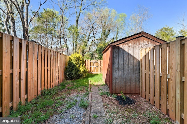 view of yard with a fenced backyard, an outbuilding, and a storage shed