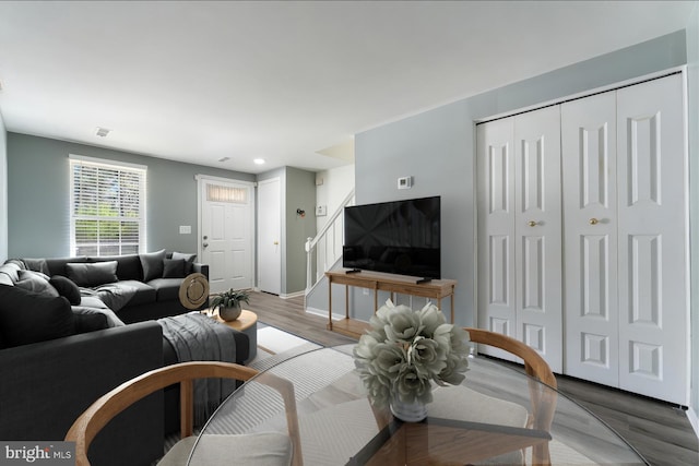 living area with recessed lighting, stairway, wood finished floors, visible vents, and baseboards