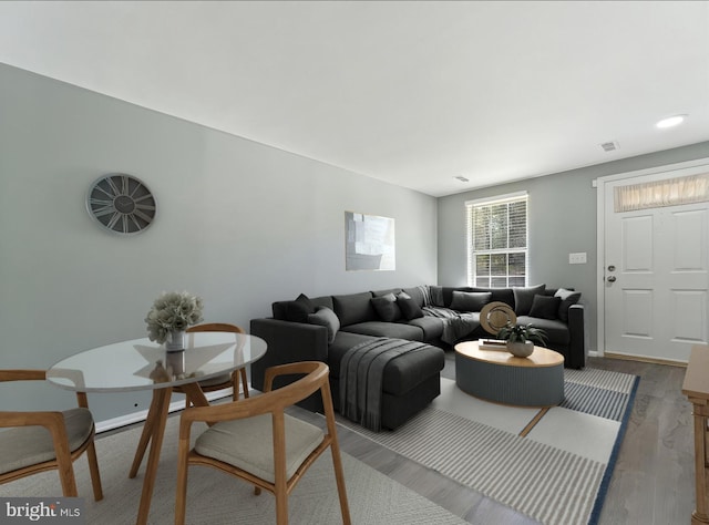 living area featuring wood finished floors, visible vents, and baseboards