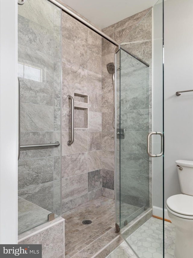 full bath featuring tile patterned flooring, toilet, and a stall shower