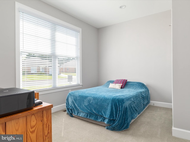 carpeted bedroom with baseboards and multiple windows