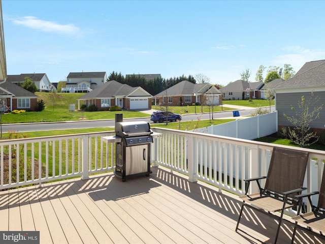 wooden terrace featuring a yard, fence, a residential view, and area for grilling