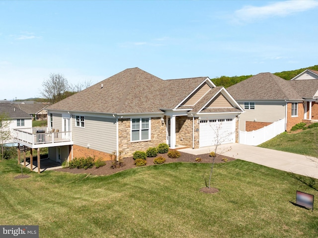 view of front of house featuring fence, concrete driveway, a garage, a deck, and a front yard