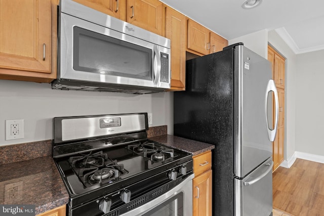 kitchen with stainless steel appliances, baseboards, and crown molding