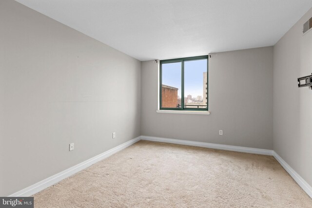 carpeted empty room featuring baseboards