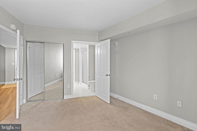 unfurnished bedroom featuring a closet, baseboards, and carpet