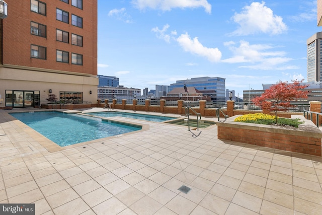 view of pool with a patio area and a city view