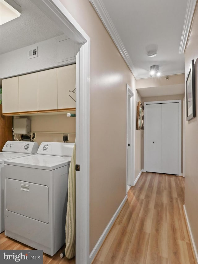 5505 Seminary Rd Unit 605N, Falls Church, VA 22041 - laundry room featuring visible vents, ornamental molding, washing machine and dryer, light wood-style flooring, and cabinet space
