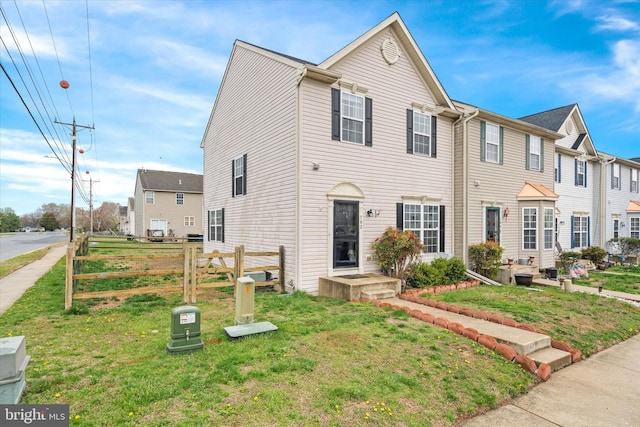 townhome / multi-family property with fence and a front yard