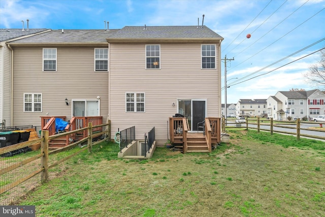 back of house with a fenced backyard, a lawn, and a deck