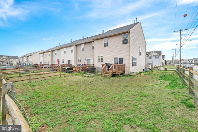 rear view of property featuring a fenced backyard, a lawn, a residential view, and a wooden deck
