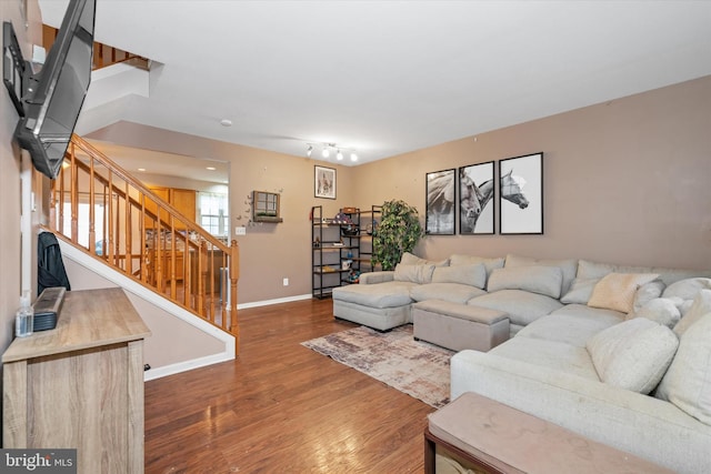 living room with baseboards, stairway, and wood finished floors