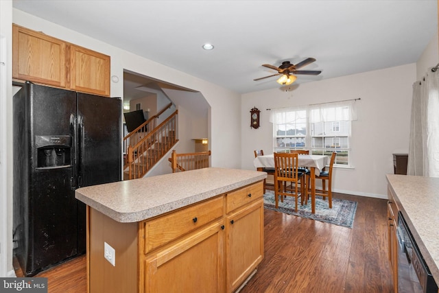 kitchen featuring light countertops, black fridge with ice dispenser, dark wood-style flooring, dishwasher, and a ceiling fan