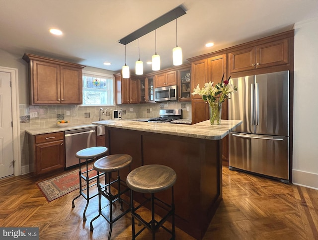 1303 N Newkirk St, Philadelphia, PA 19121 - kitchen featuring glass insert cabinets, tasteful backsplash, a center island, appliances with stainless steel finishes, and hanging light fixtures
