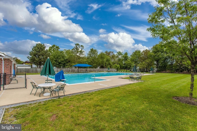 community pool featuring fence, a yard, and a patio area