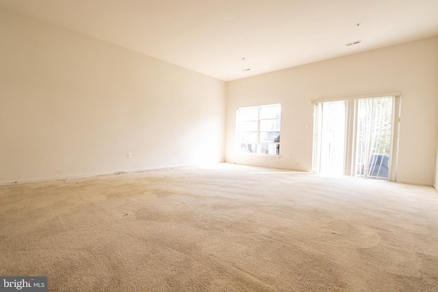 unfurnished room featuring baseboards, carpet flooring, and visible vents
