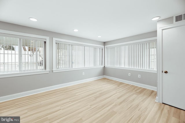 unfurnished room featuring baseboards, visible vents, wood finished floors, and recessed lighting