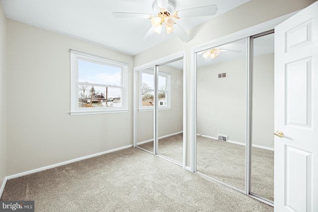unfurnished bedroom featuring carpet flooring, multiple closets, and visible vents