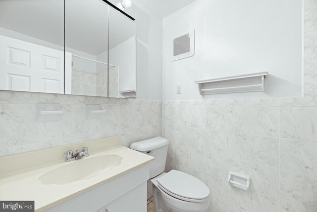 bathroom featuring tile walls, toilet, and vanity
