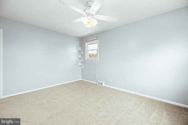 spare room featuring baseboards, carpet flooring, visible vents, and a ceiling fan