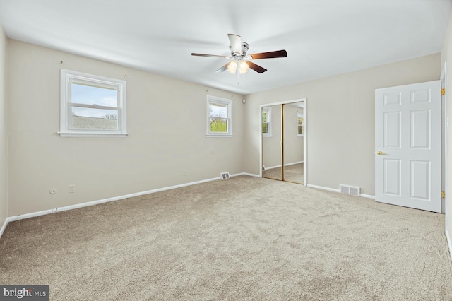 unfurnished bedroom with baseboards, carpet floors, visible vents, a ceiling fan, and a closet