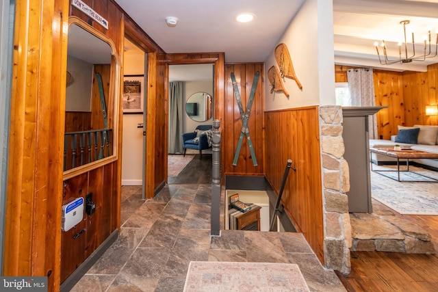 16 Jrs Dr, Mc Henry, MD 21541 - hallway featuring an inviting chandelier, wainscoting, wood walls, and stone finish flooring