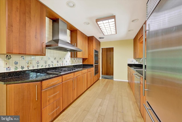 1408 Margarette Ave, Baltimore, MD 21286 - kitchen featuring wall chimney exhaust hood, stainless steel appliances, tasteful backsplash, light wood-style flooring, and dark stone counters