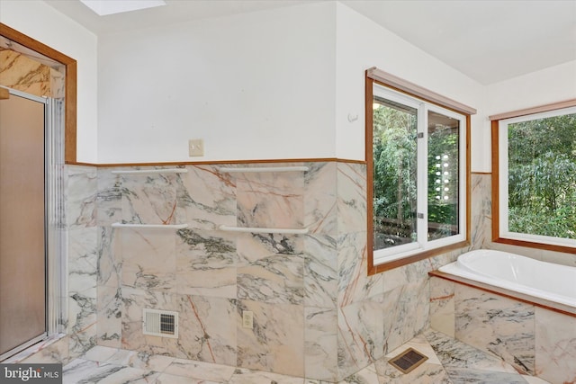 1408 Margarette Ave, Baltimore, MD 21286 - bathroom with marble tiled floors, a garden tub, a marble finish shower, wainscoting, and tile walls