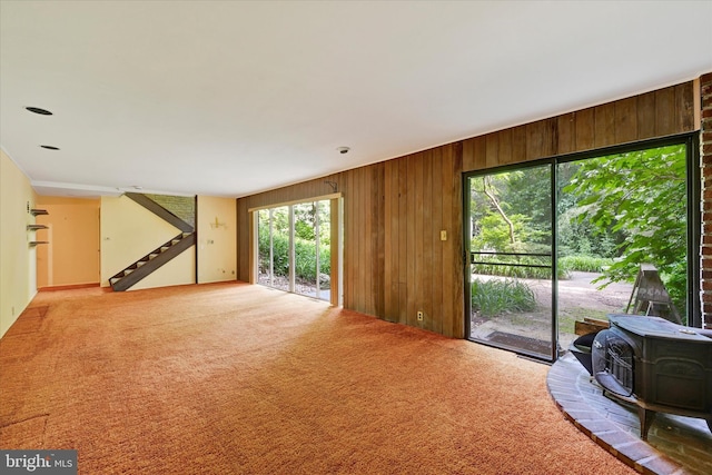 1408 Margarette Ave, Baltimore, MD 21286 - living room with wooden walls, a wood stove, carpet floors, and stairway