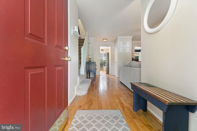 foyer entrance with baseboards and light wood-style floors