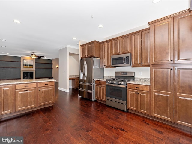 kitchen featuring recessed lighting, brown cabinets, light stone countertops, dark wood-type flooring, and appliances with stainless steel finishes