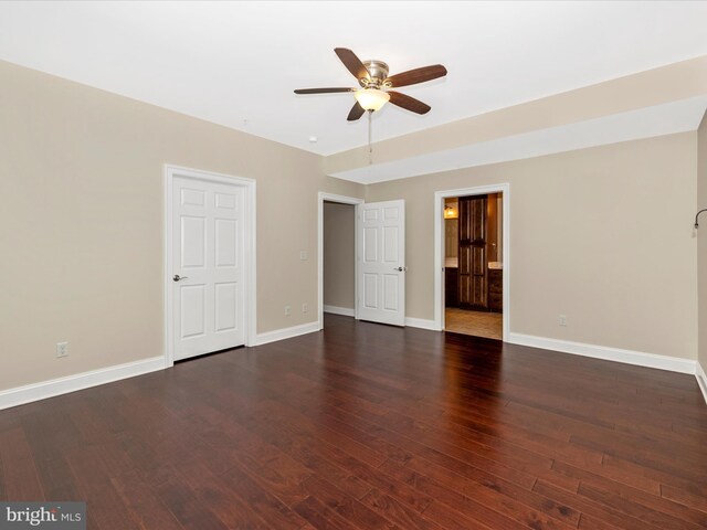 interior space featuring wood finished floors, ensuite bath, and baseboards