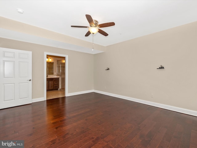 spare room with dark wood-type flooring, baseboards, and ceiling fan
