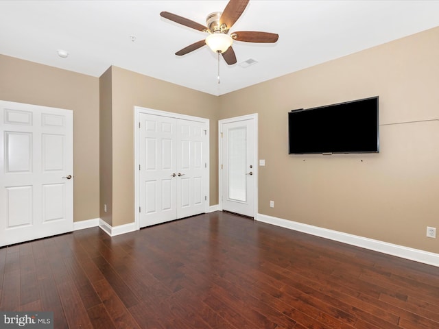 unfurnished bedroom with baseboards, visible vents, ceiling fan, and dark wood finished floors