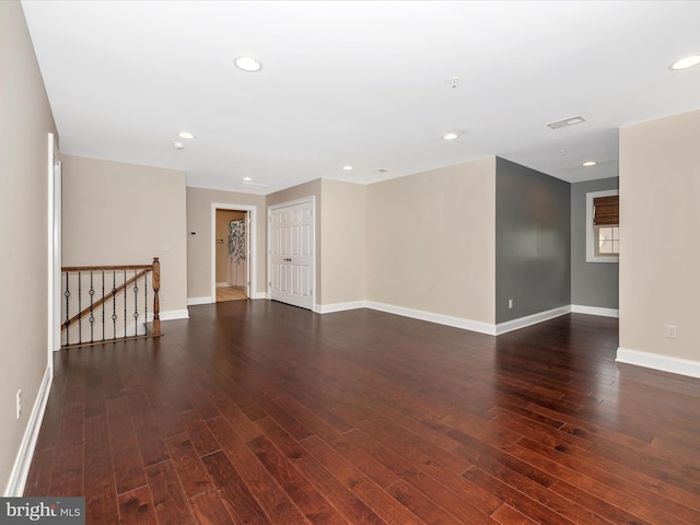 spare room featuring recessed lighting, dark wood finished floors, visible vents, and baseboards