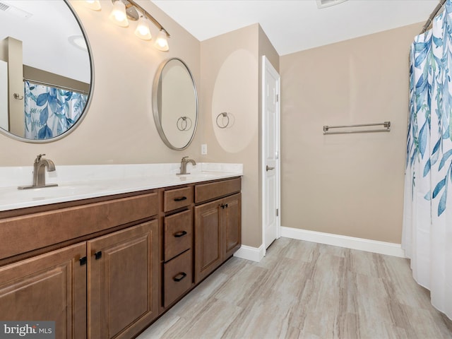 full bathroom featuring baseboards, visible vents, a sink, and double vanity