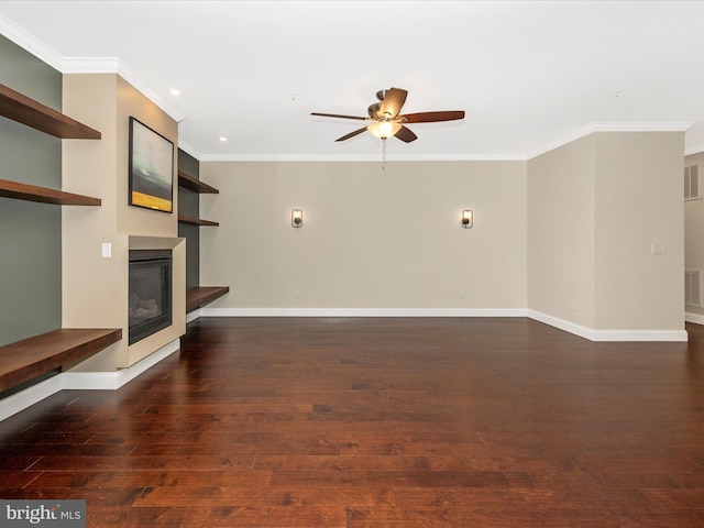 unfurnished living room with wood finished floors, ornamental molding, baseboards, a glass covered fireplace, and ceiling fan