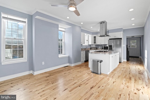 kitchen with light wood-style flooring, island range hood, appliances with stainless steel finishes, and baseboards