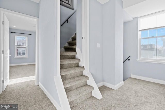 staircase with baseboards and carpet